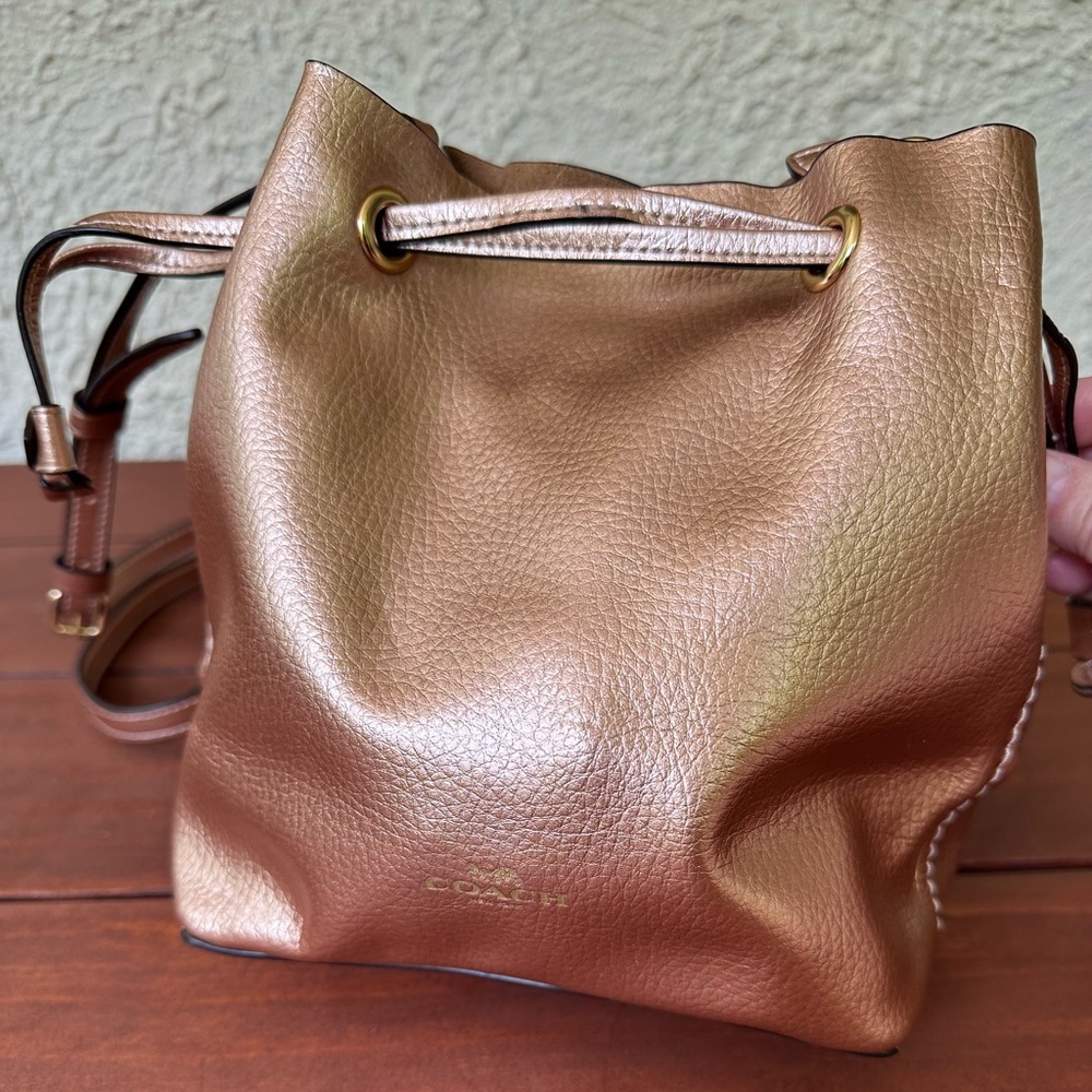 Coach drawstring pouch purse with snap closure and inside pocket.